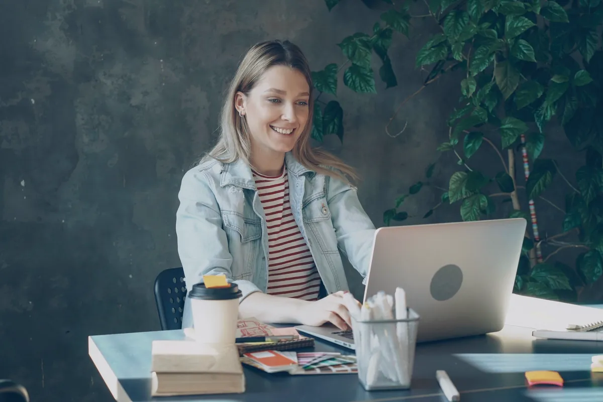 Young woman smiling while working on her laptop